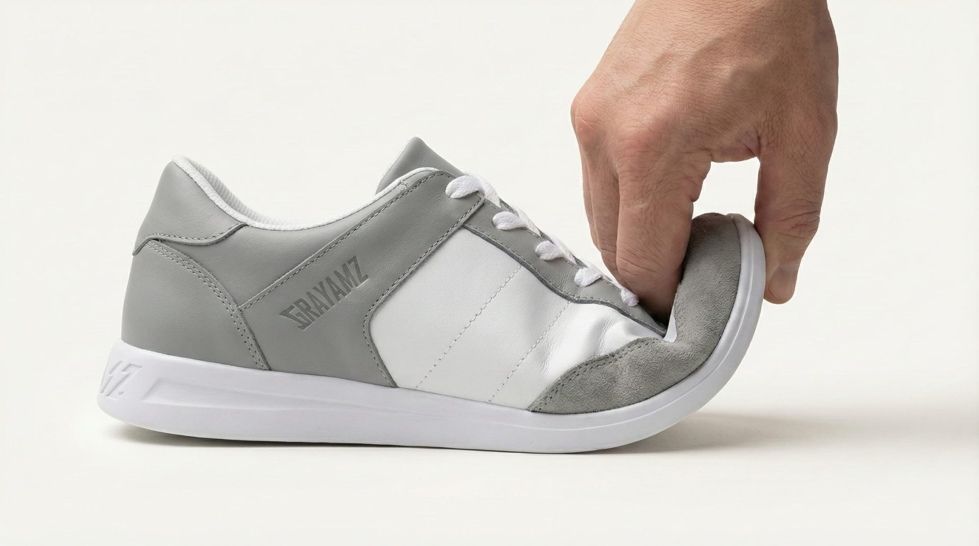 Hand bending GRAYAMZ shoe to demonstrate flexibility